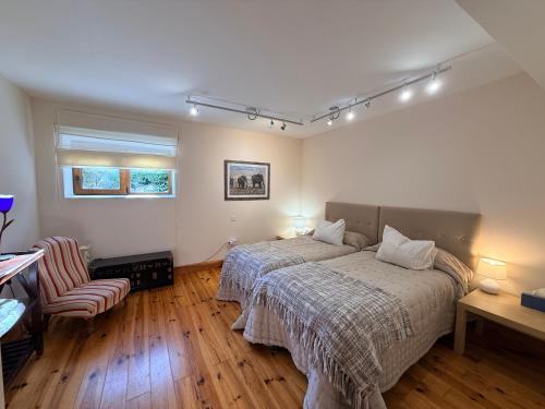 a bedroom with a bed and a chair in it at Espacioso e independiente apartamento in Las Rozas de Madrid