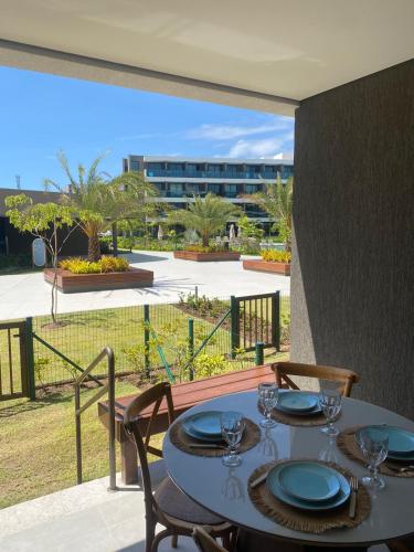 a table with plates and glasses on a balcony at Flat Garden 02-A - Beach Class Verano - Porto de Galinhas in Ipojuca