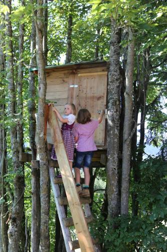 two children are standing in a tree house at Kasperbauer in Kirchberg in Tirol