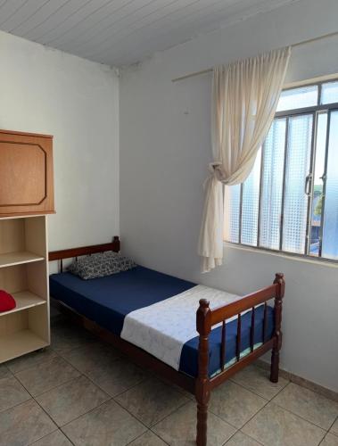 a bedroom with a bed and a window at Pousada da Salete in Campo Mourão
