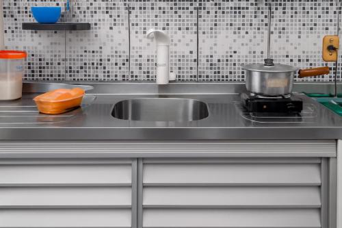 a kitchen sink with a pot on a stove at Quarto - Room Econômico da Maricotinha - No Air Cond in Manaus