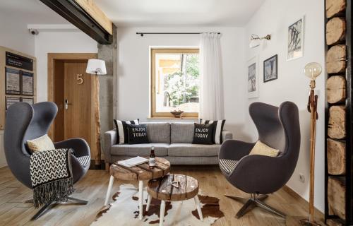 a living room with two chairs and a couch at Villa 11 Folk & Design in Zakopane