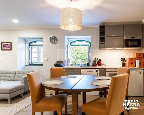 a kitchen and living room with a table and chairs at Quinta de São José by PontaNegraAzores in Angra do Heroísmo
