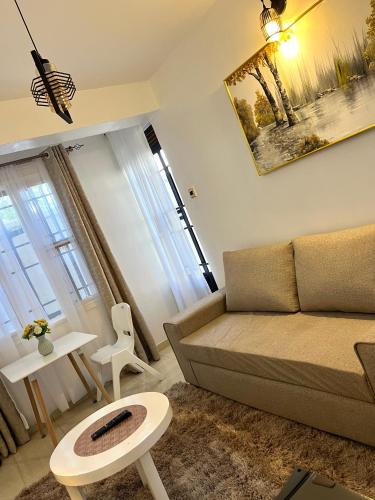 a living room with a couch and a table at Stylish 1br Milimani in Kisumu