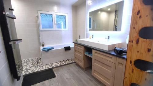 a bathroom with a sink and a tub and a shower at Le lavoir in Moiry