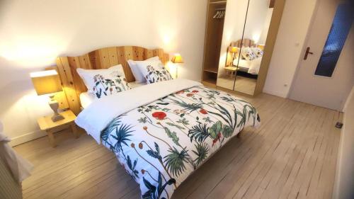 a bedroom with a bed with a floral bedspread at Le lavoir in Moiry