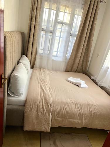 a bed in a room with a window at Stylish 1br Milimani in Kisumu
