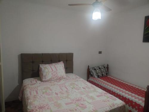 a bedroom with a bed and a ceiling fan at Suites no centro, Salto-SP in Salto