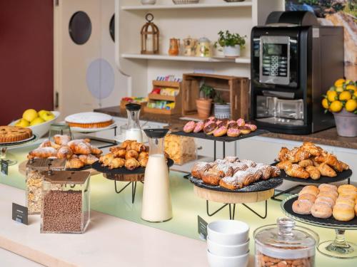 a bakery counter with various pastries and other food items at B&B HOTEL Eurorest Conegliano in Conegliano