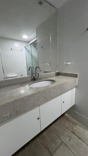 a bathroom with a sink and a mirror at Pé na Areia no Cumbuco - Eco Paradise 110 in Caucaia