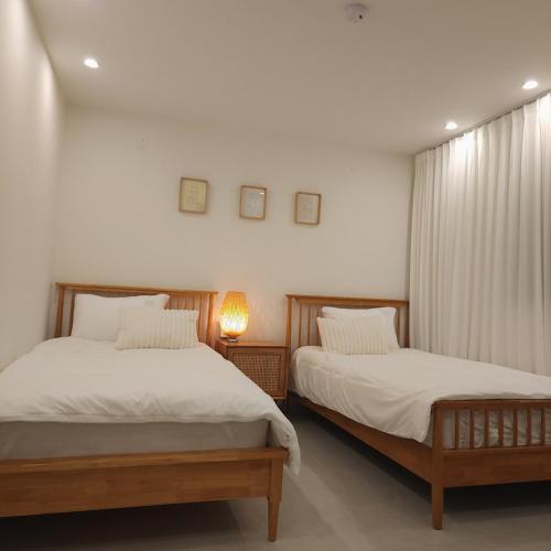 a bedroom with two beds and a lamp at COZY stay in Seoul