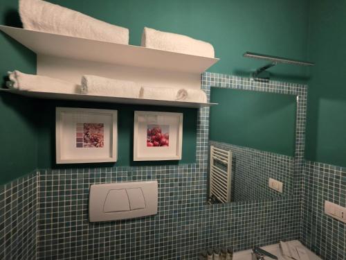 a bathroom with green walls and a toilet with towels at Guest House Seataly - by Be Your Home in Civitavecchia