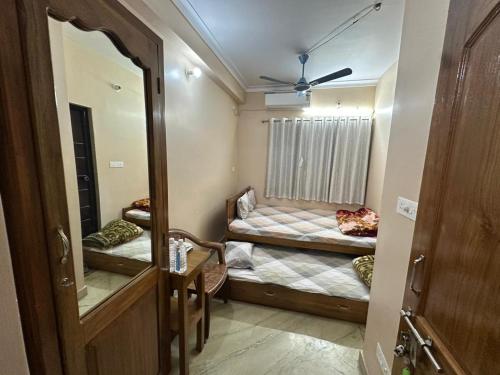a small room with two beds and a mirror at Sudama Bhavan in mayapur