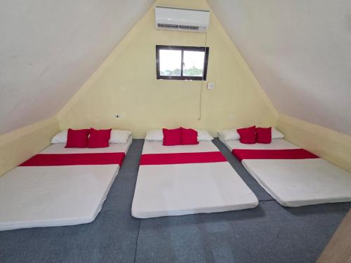 a attic room with two beds with red pillows at Shukran Habibi Resort in Santa Rita