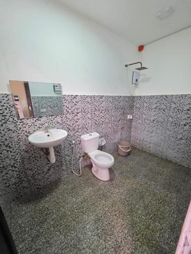 a bathroom with a pink toilet and a sink at Shukran Habibi Resort in Santa Rita
