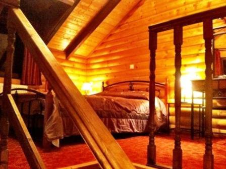 a bedroom with a bed in a log cabin at mezonetaki in Karpenisi