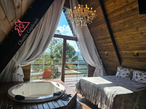 a room with a tub and a bed and a window at Chale Capivari Estrela in Campos do Jordão
