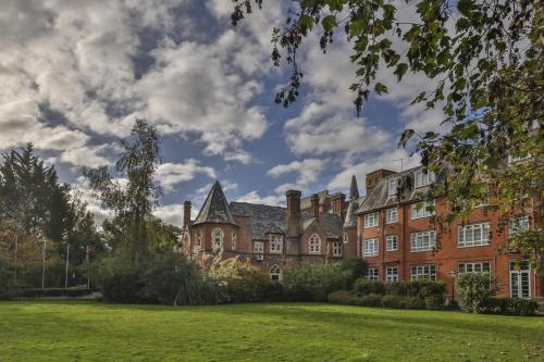 a large brick building with a green lawn at Best Western Abbots Barton Hotel in Canterbury