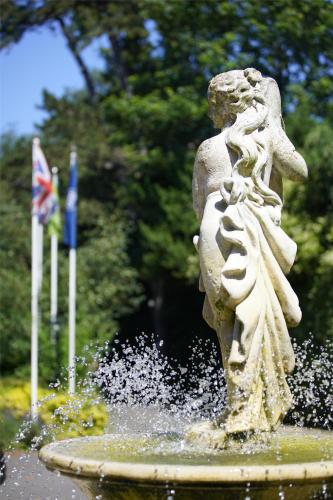 a statue of a girl sitting in a fountain at Best Western Abbots Barton Hotel in Canterbury