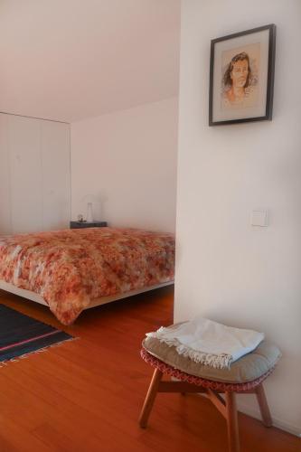 a room with a bed and a stool and a picture at Bloom - Beach House in Apúlia