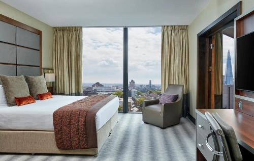 a hotel room with a bed and a large window at Leonardo Royal London Tower Bridge in London