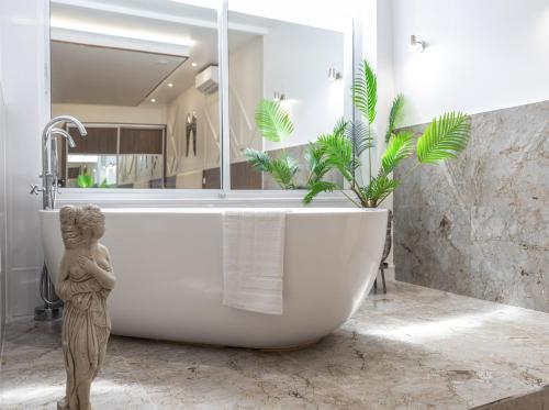 a bathroom with a bath tub with a statue in it at The Pocklington Aparthotel - Luxury 1 & 2 Bed Serviced Apartments, City Centre, Perfect For Families, Contractors and Businesses in Leicester