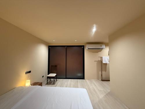 a bedroom with a large white bed and a sliding door at Homey Bamboo Lanta in Ban Ai Dao