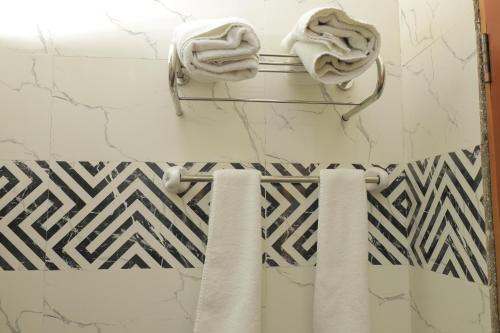 a bathroom with black and white tiles and towels at History Hotel in Dirē Dawa