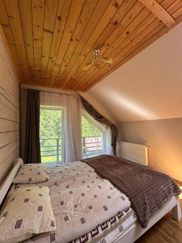 a large bed in a room with a large window at Guest house Alyaska in Bukovel