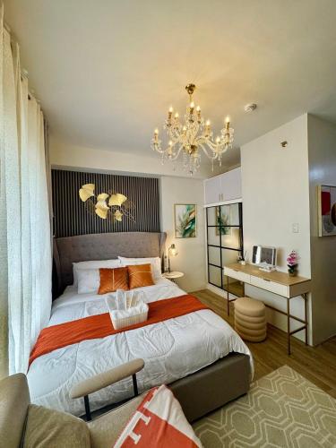 a bedroom with a large bed and a chandelier at Ona's Condo in Bacolod