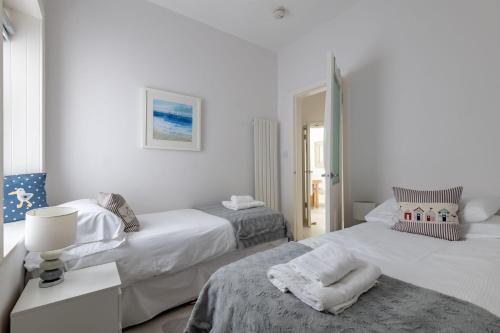two beds in a room with white walls at Bakers Close - Elie in Elie