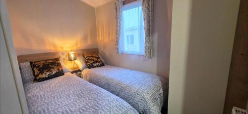 a bedroom with two beds and a window at Graham's Dream in Heysham