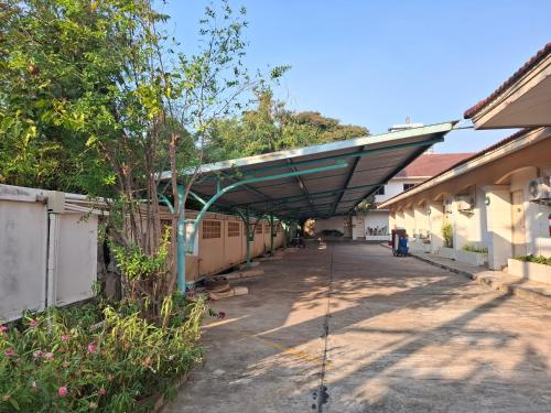 a building with awning over a walkway in a yard at Picnic Si Racha in Ban Fang Daeng