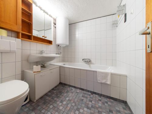 a bathroom with a toilet and a sink and a tub at das Sopherl in Sonnenalpe Nassfeld