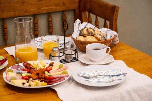 a table with plates of food and a basket of bread at Tündérliget in Egerszalók
