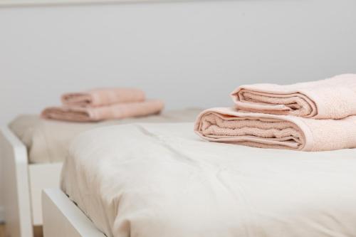 a bed with white sheets and pink towels on it at Danube Tower holiday in Vienna