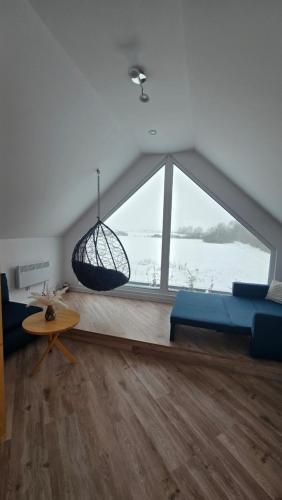 a living room with a blue couch and a large window at Riwiera Strzelecka in Strzelce Małe