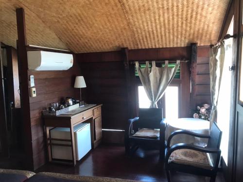 a living room with a table and chairs in a room at Ayothaya Riverside House in Phra Nakhon Si Ayutthaya