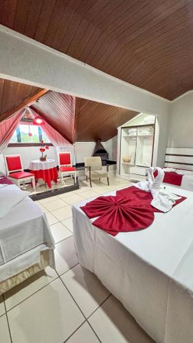 a bedroom with a large bed with a red dress on it at Hotel do Papai Noel in Penedo