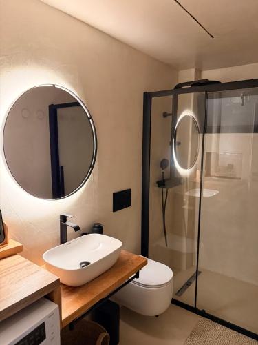 a bathroom with a sink and a toilet and a mirror at Kudos Luxury villas in Korinthos