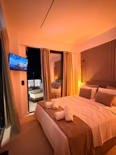 a bedroom with a large bed with towels on it at Kudos Luxury villas in Korinthos