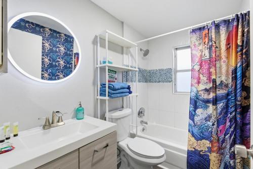 a bathroom with a sink toilet and a shower curtain at MERMAID HOUSE WITH POOL JACUZZI STEPS to SIESTA KEY BEACH in Sarasota
