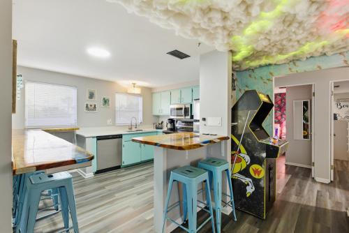 a kitchen with blue and green cabinets and blue stools at MERMAID HOUSE WITH POOL JACUZZI STEPS to SIESTA KEY BEACH in Sarasota