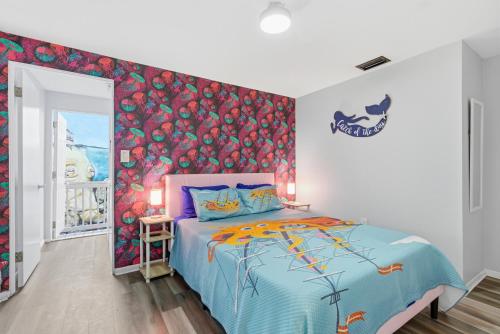 a bedroom with a bed with a colorful wall at MERMAID HOUSE WITH POOL JACUZZI STEPS to SIESTA KEY BEACH in Sarasota