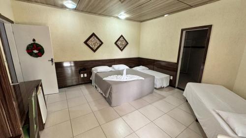 a room with two beds and a table in it at Hotel do Papai Noel in Penedo