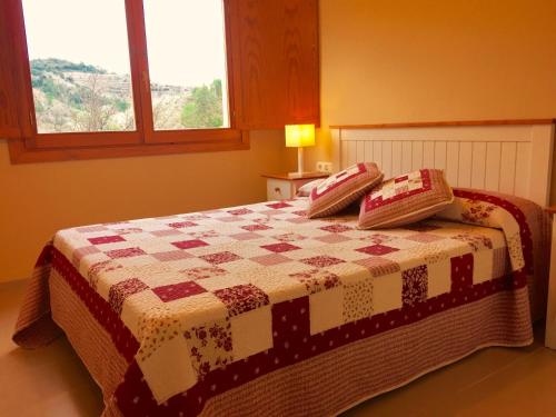 a bedroom with a bed with a quilt on it at Apartament Escaladei in Escaladei