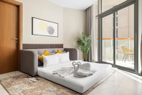 a living room with a bed with a swan on it at Unlock Waters Edge in Dubai