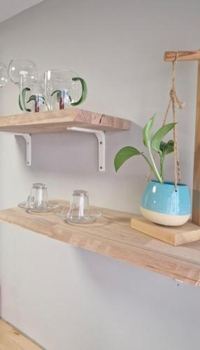 a shelf with glasses and a plant on it at Meu Sonho Cascais - Praia in Alcabideche
