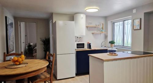 a kitchen with a table and a white refrigerator at Meu Sonho Cascais - Praia in Alcabideche