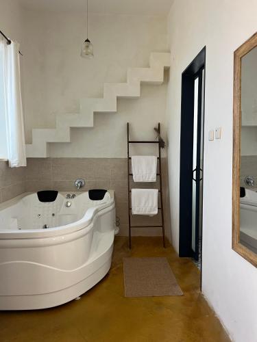 eine Badewanne in einem Badezimmer mit einer Treppe in der Unterkunft Yamas Golan in Ani'am